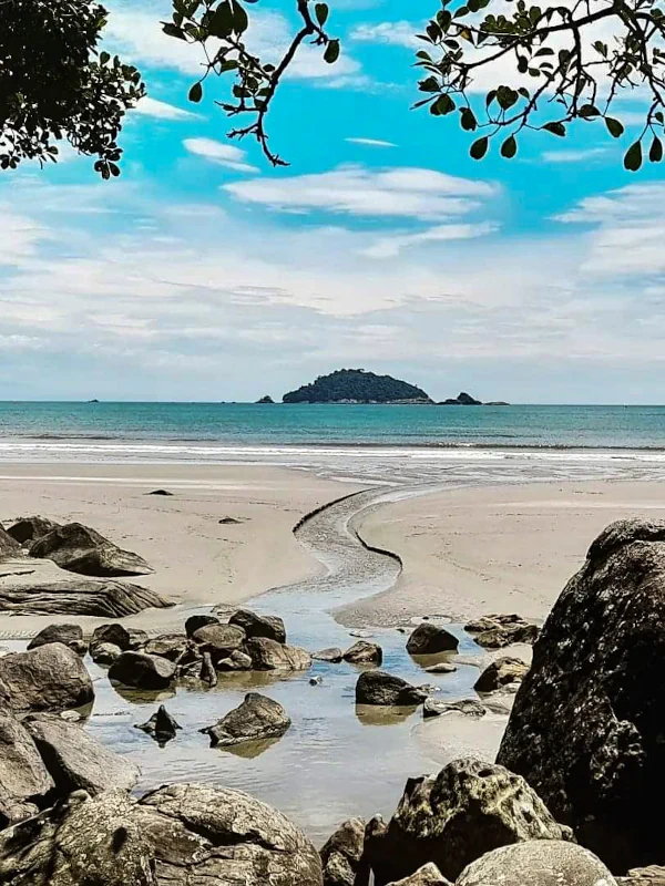 Riacho na Praia do Arpoador com o mar e a Ilha do Guarau ao fundo.