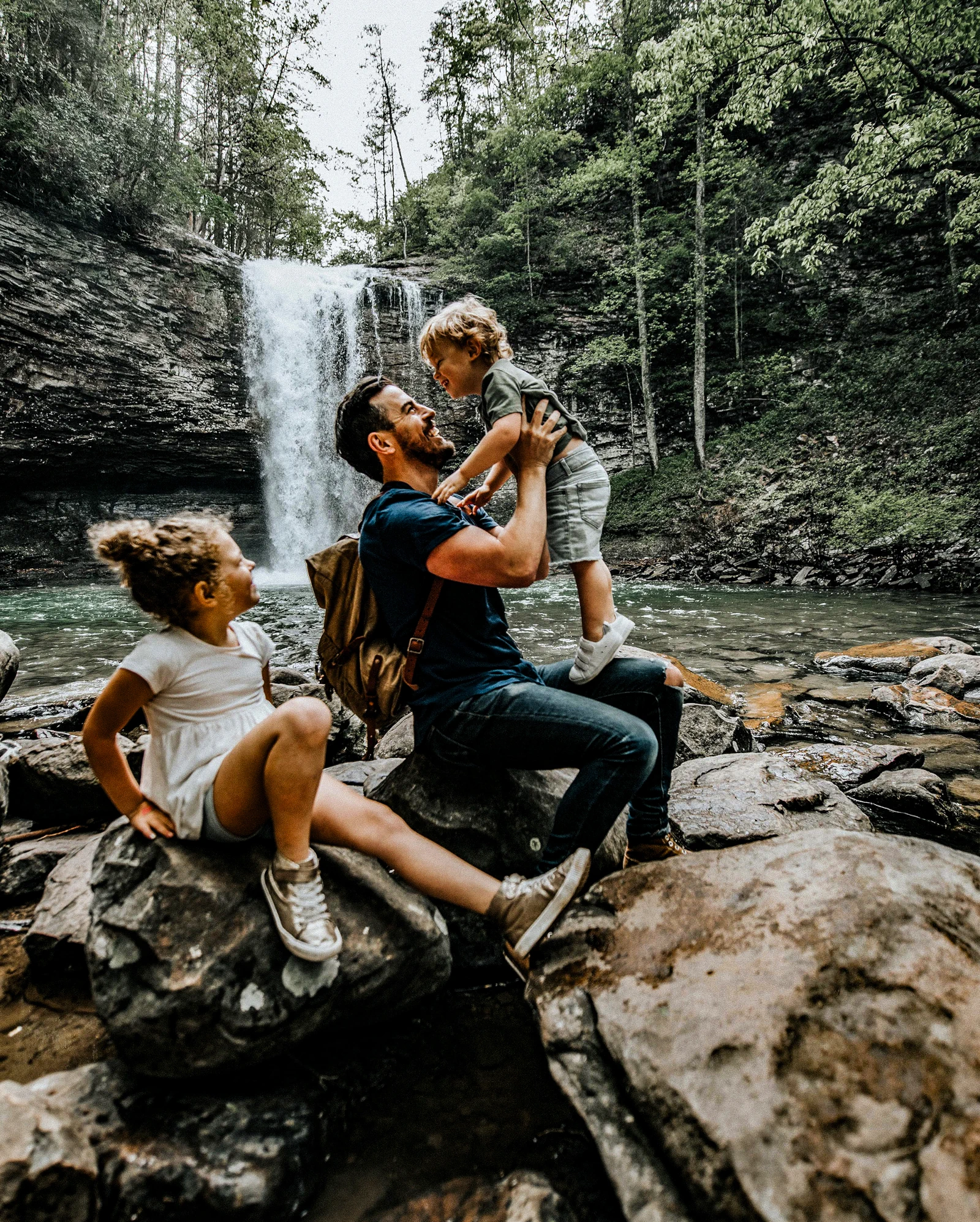 Família de turistas se divertindo em cachoeira.